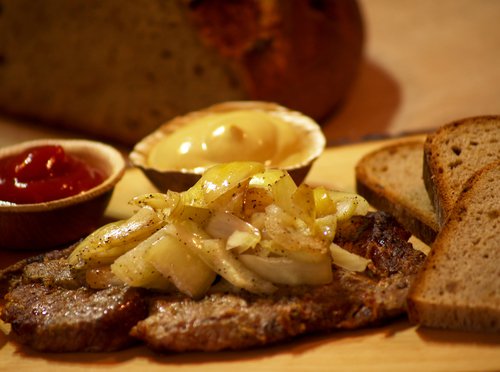 Brätl mit gebratenen Zwiebeln darauf