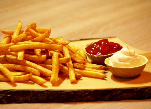 Pommes mit zwei Schälchen Ketchup und Mayonaise