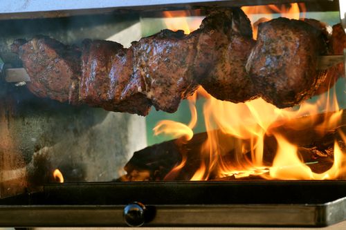 Ein Spieß mit Mutzbraten über dem Feuer