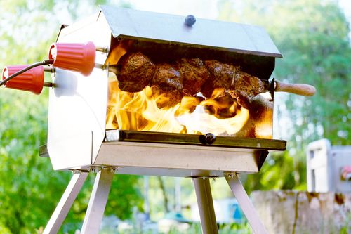 Ein Topf mit Sauerkraut auf einem Mutzbratengrill, darunter Mutzbraten